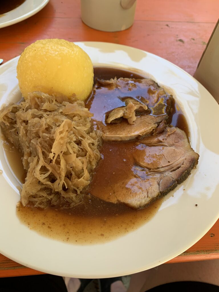 Teller mit einem Kloß, Sauerkraut und Schweinebraten